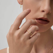 Moissanite cross ring worn on a finger.