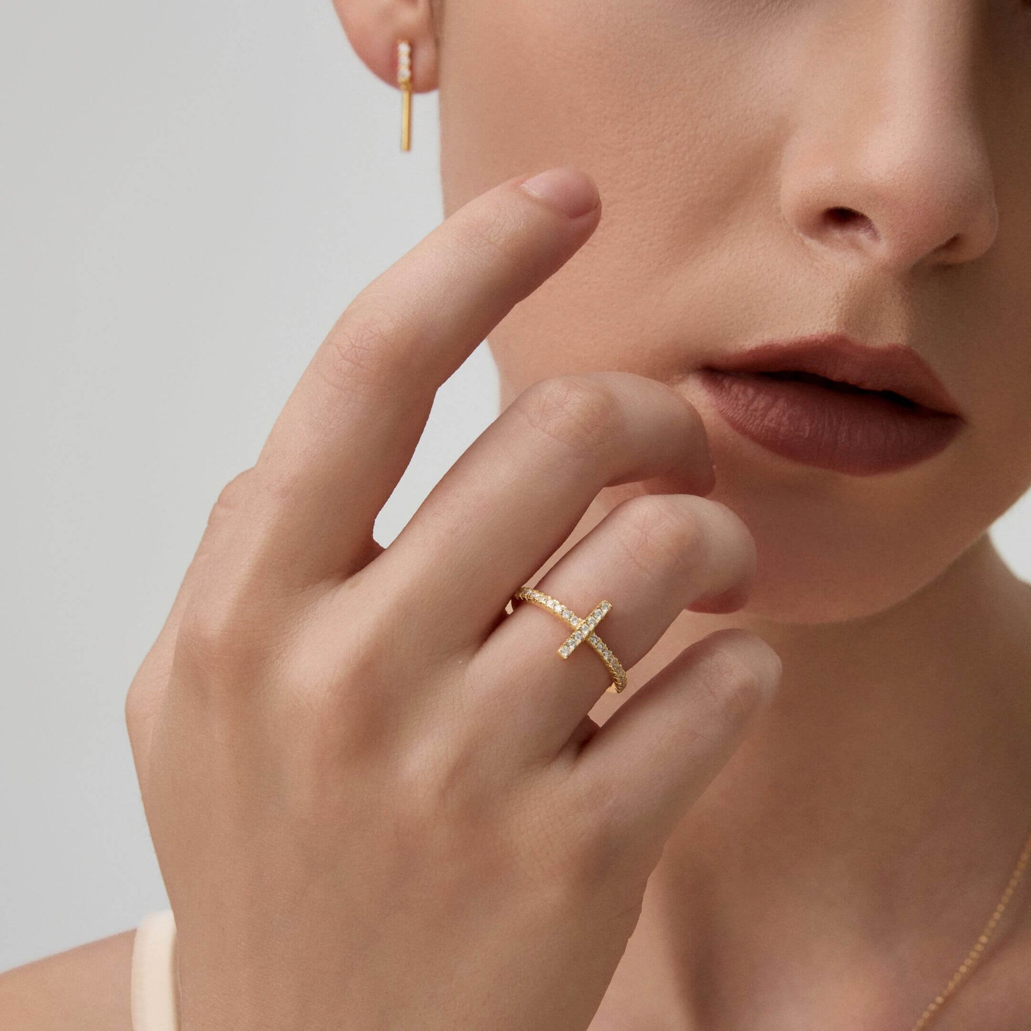 Moissanite cross ring worn on a finger.