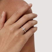 Moissanite cross ring worn on a finger.