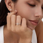 Moissanite cross ring worn on a finger.