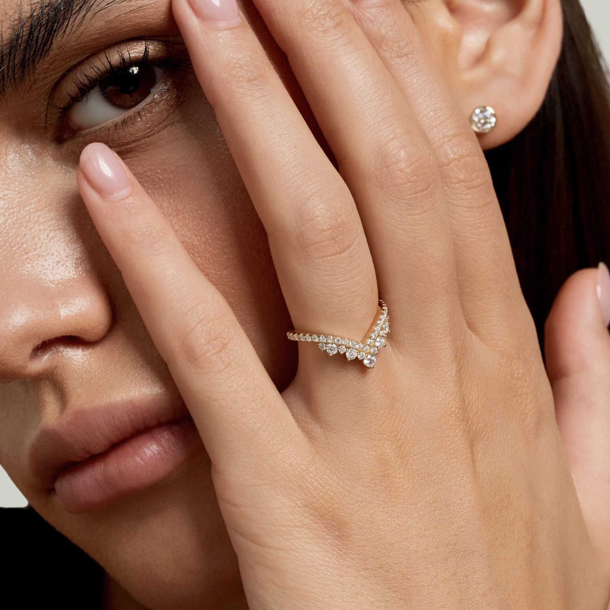 Moissanite crown ring worn on a finger.