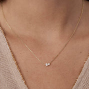 Moissanite duo necklace worn at the neckline.