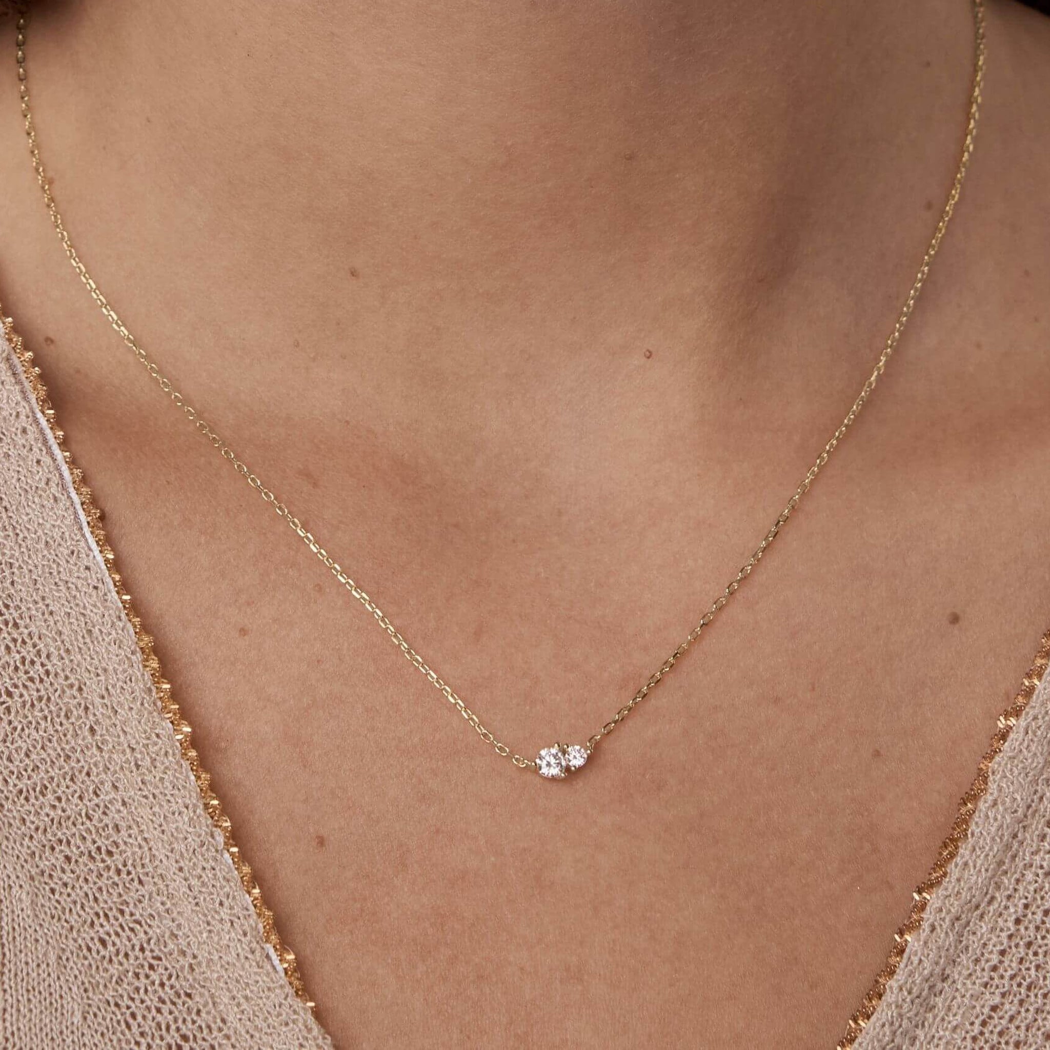 Moissanite duo necklace worn at the neckline.