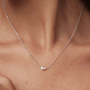 Moissanite duo necklace worn at the neckline.