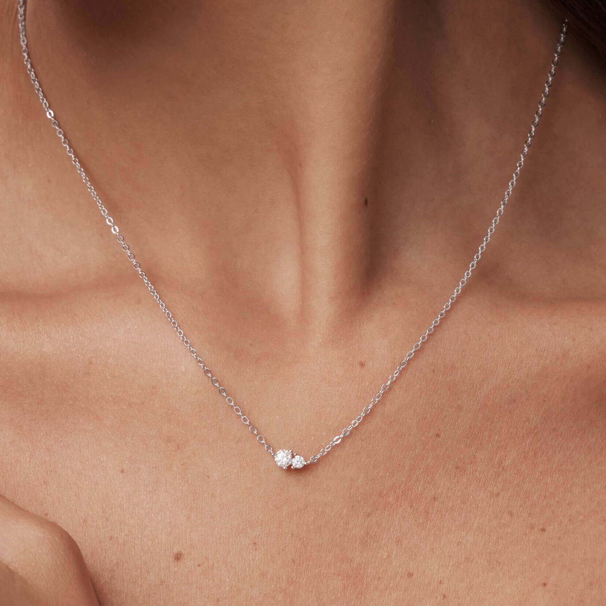 Moissanite duo necklace worn at the neckline.