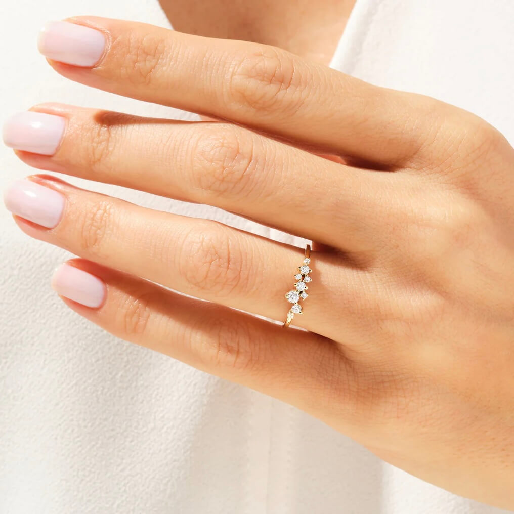 Moissanite floating cluster ring worn on a finger.