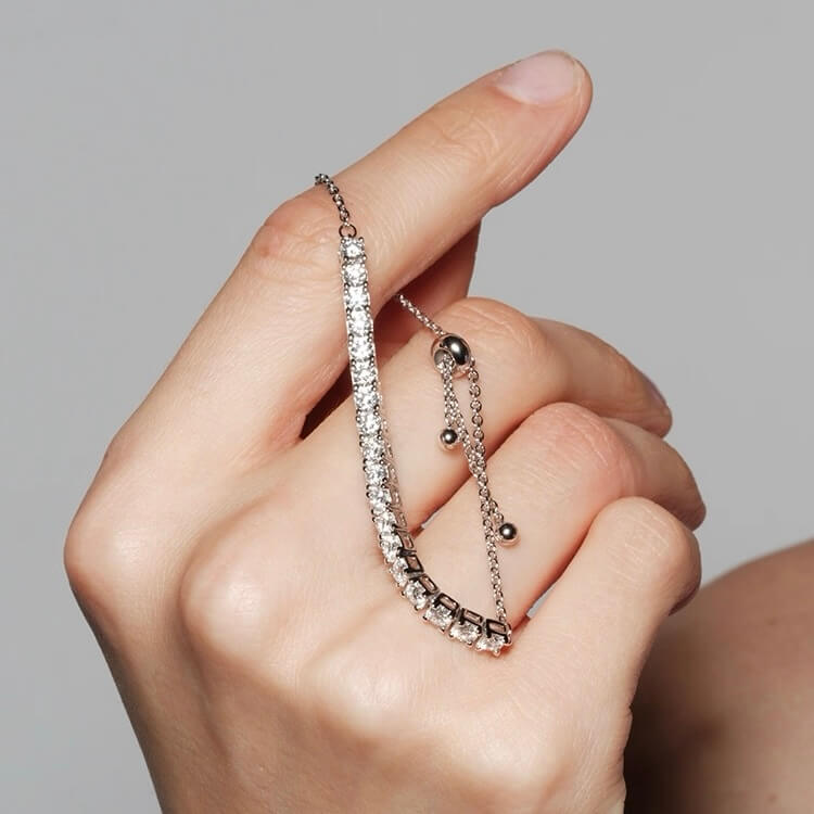 Moissanite half tennis bolo bracelet held in hand.