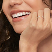 Moissanite open ring worn on a finger.