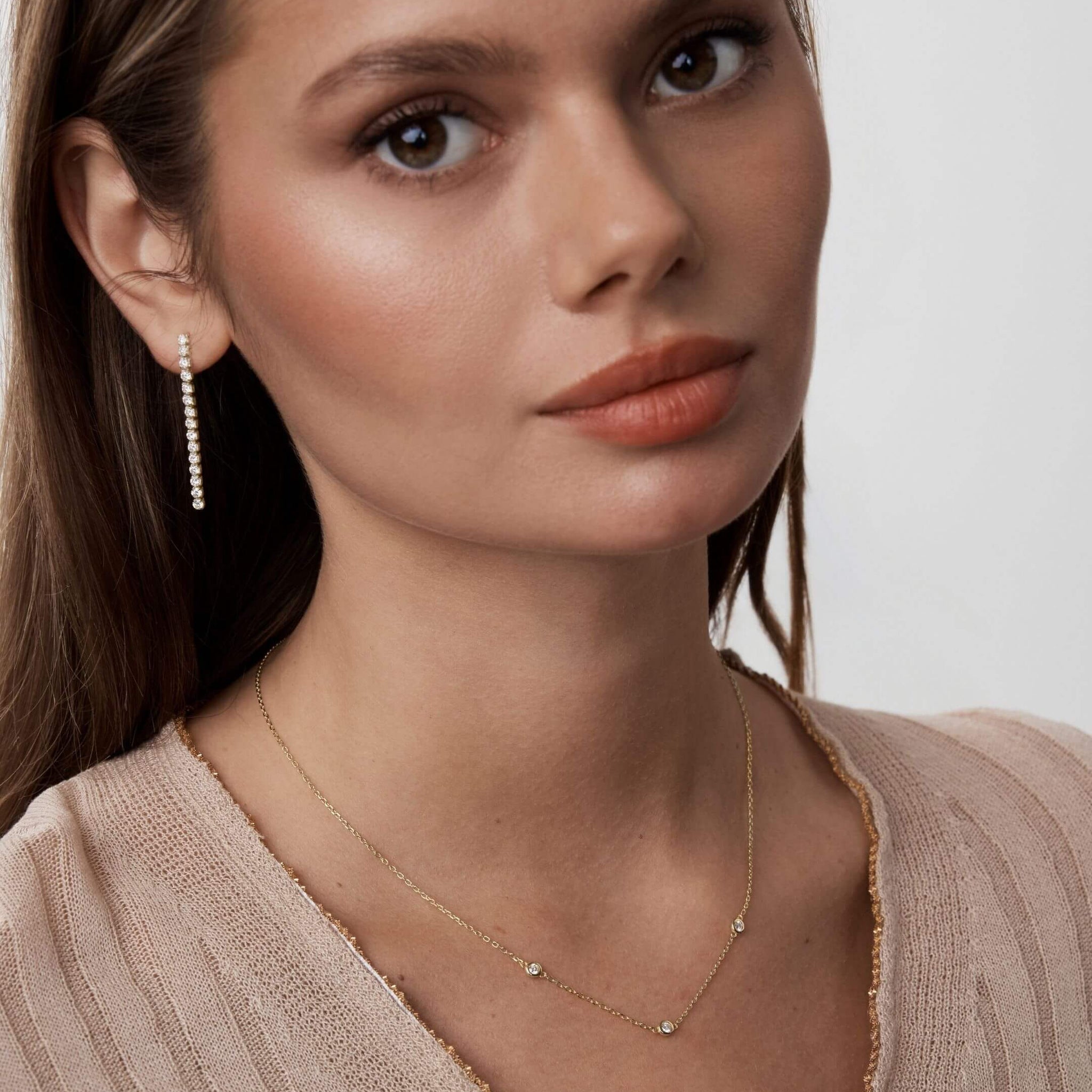 Moissanite satellite necklace worn at the neckline.