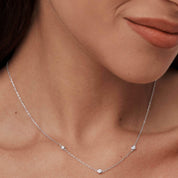 Moissanite satellite necklace worn at the neckline.