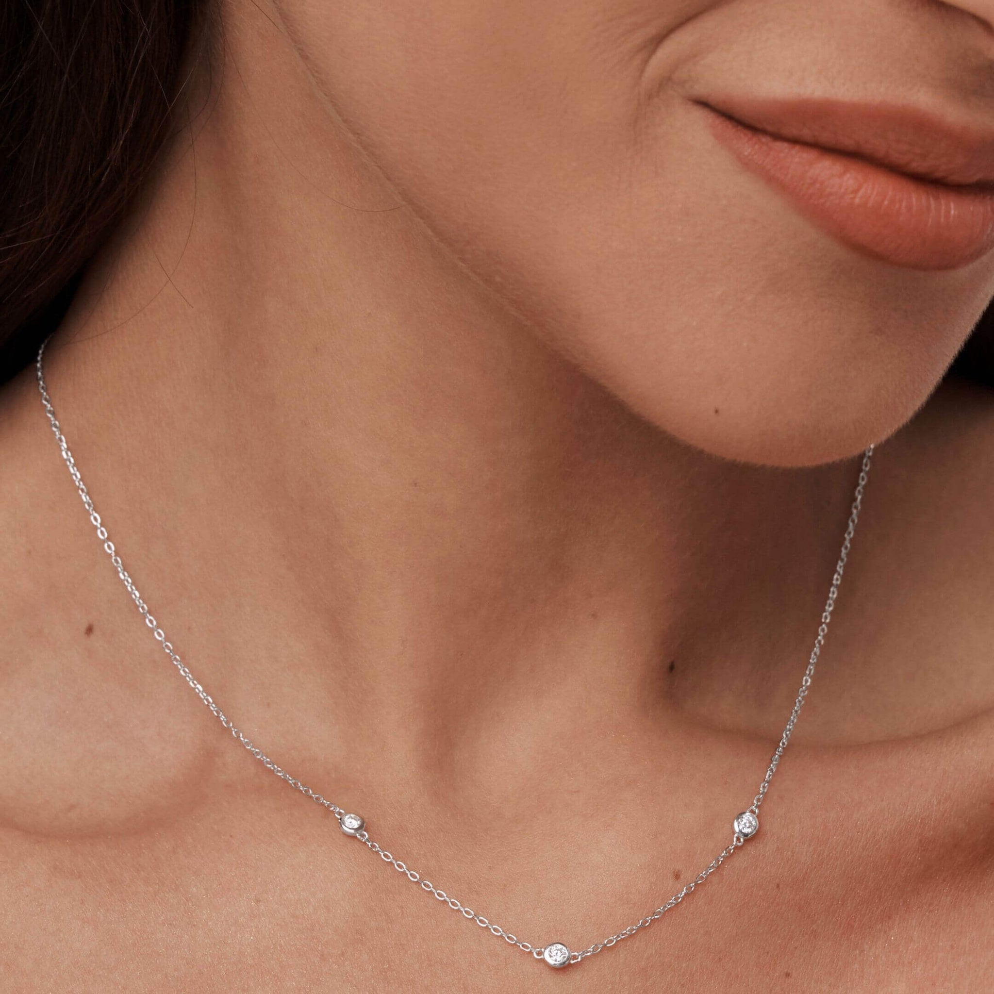 Moissanite satellite necklace worn at the neckline.