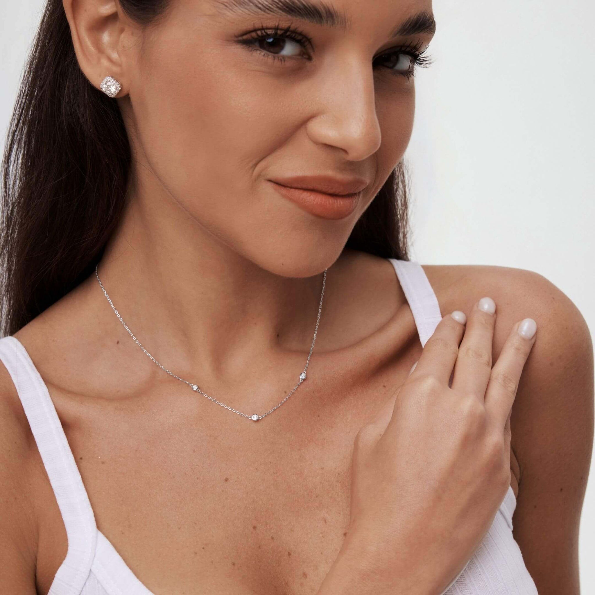 Moissanite satellite necklace worn at the neckline.