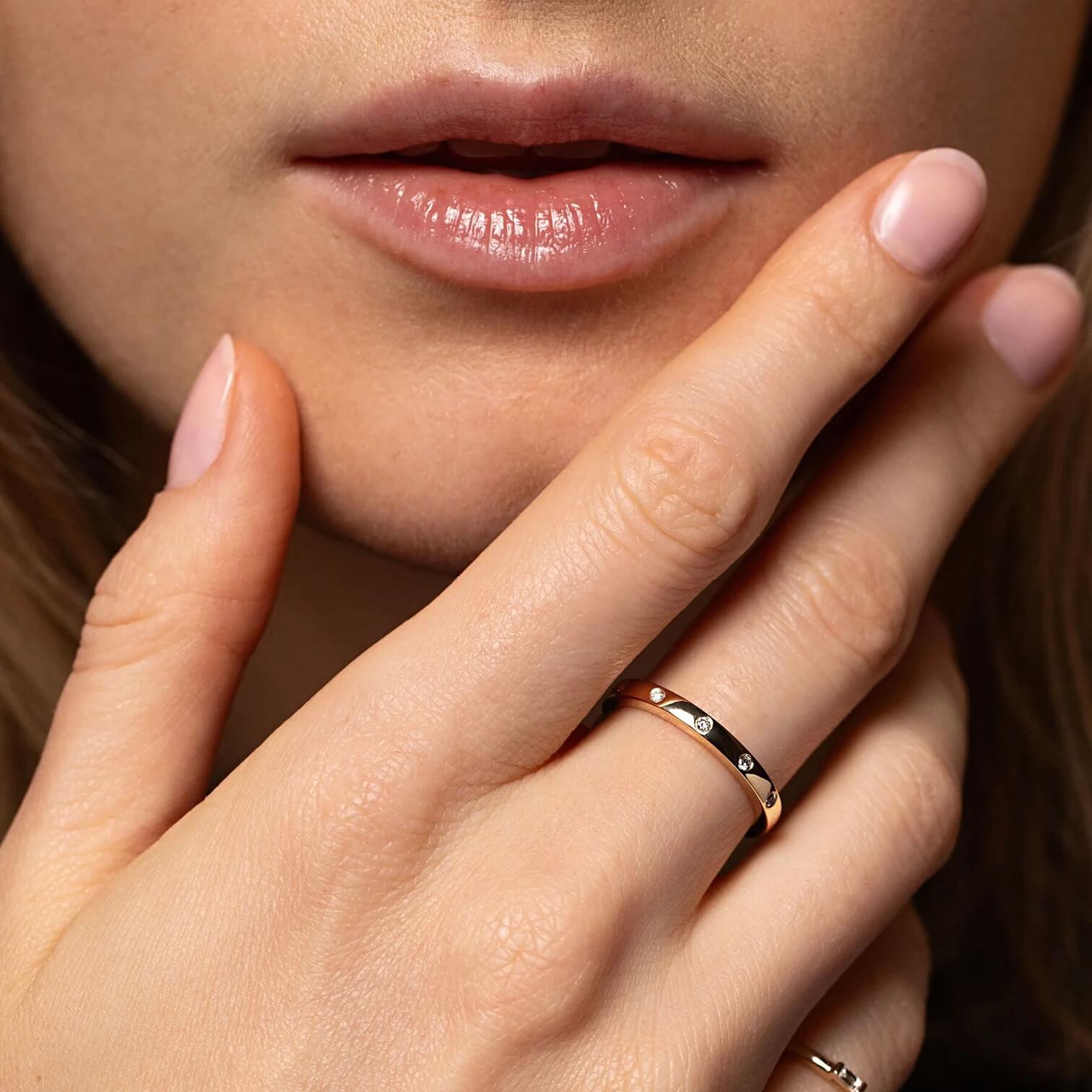 Moissanite station ring worn on a finger.