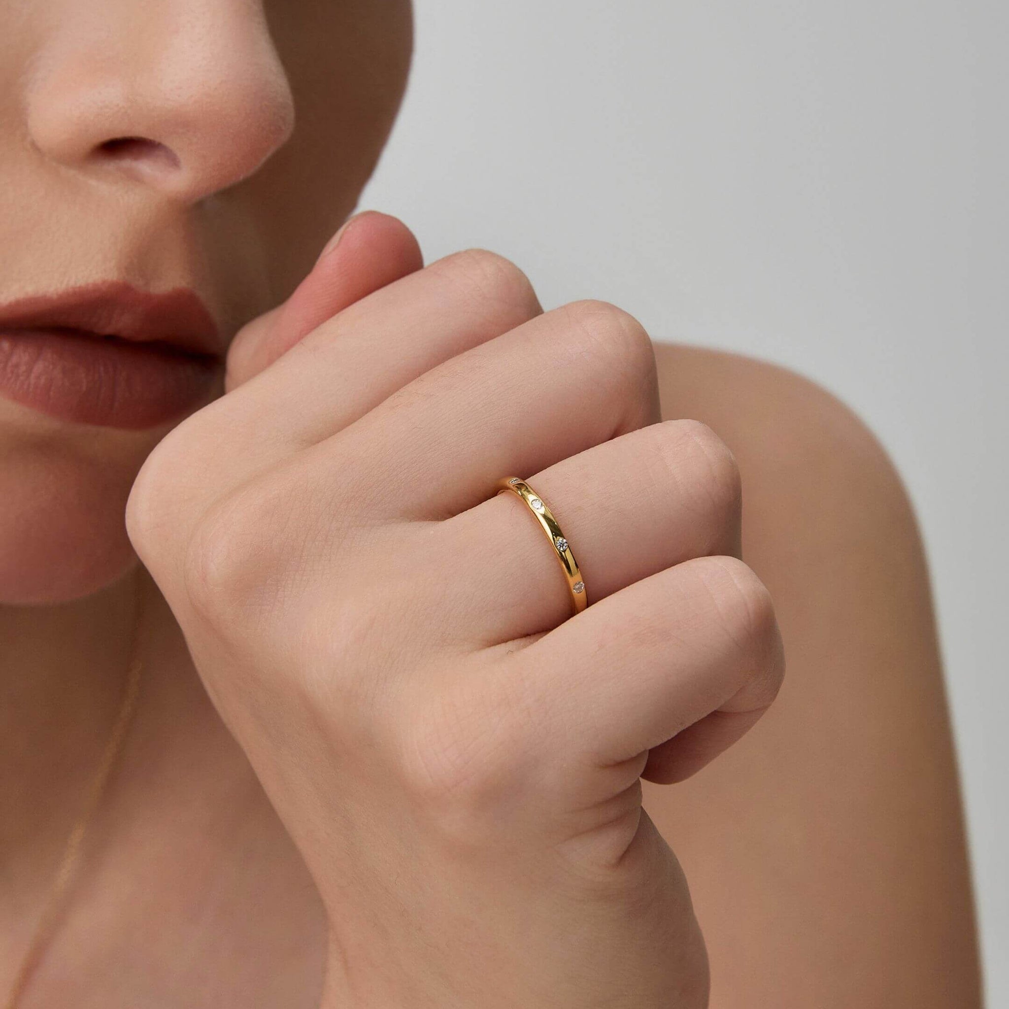 Moissanite station ring worn on a finger.