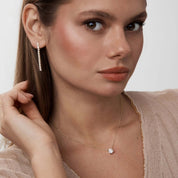 Moissanite tennis drop earrings worn on the ear.