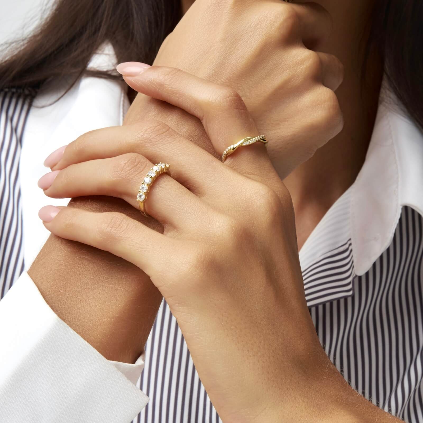 Moissanite twisted ring worn on a finger.