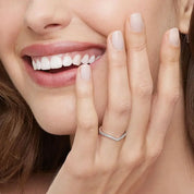 Moissanite v-shaped ring worn on a finger.