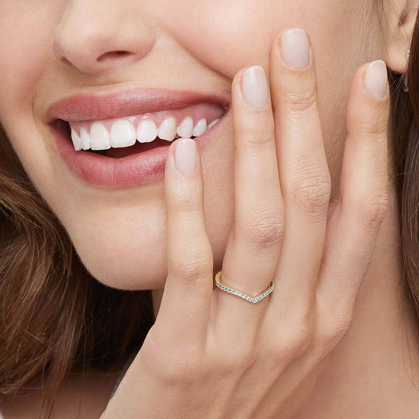 Moissanite v-shaped ring worn on a finger.