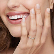 Moissanite v-shaped ring worn on a finger.