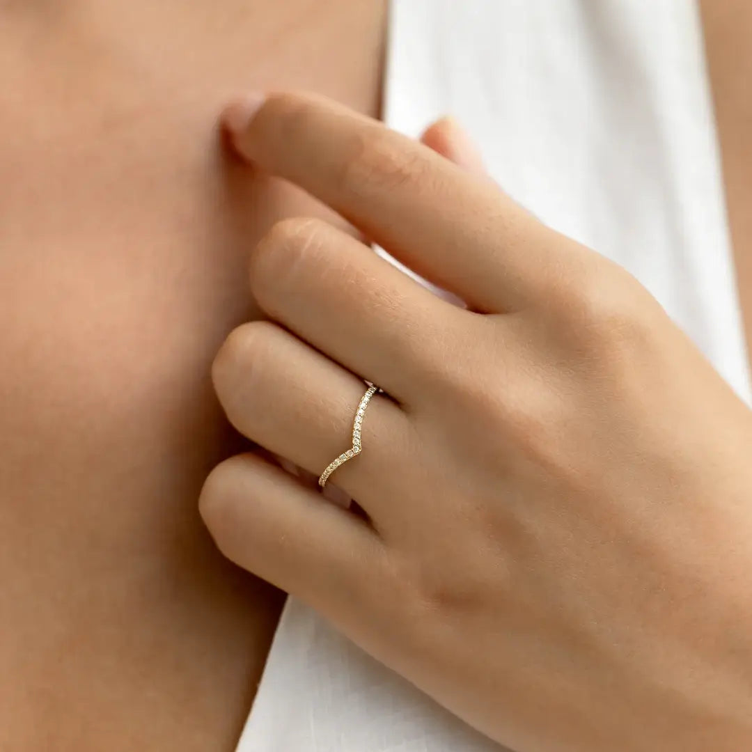 Moissanite v-shaped ring worn on a finger.
