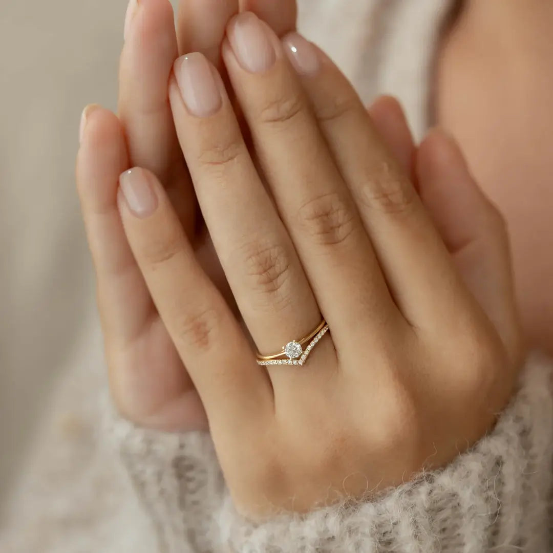 Moissanite v-shaped ring worn on a finger.