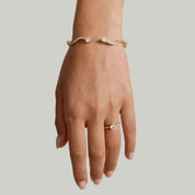Moissanite wavy cuff bracelet worn on the wrist.