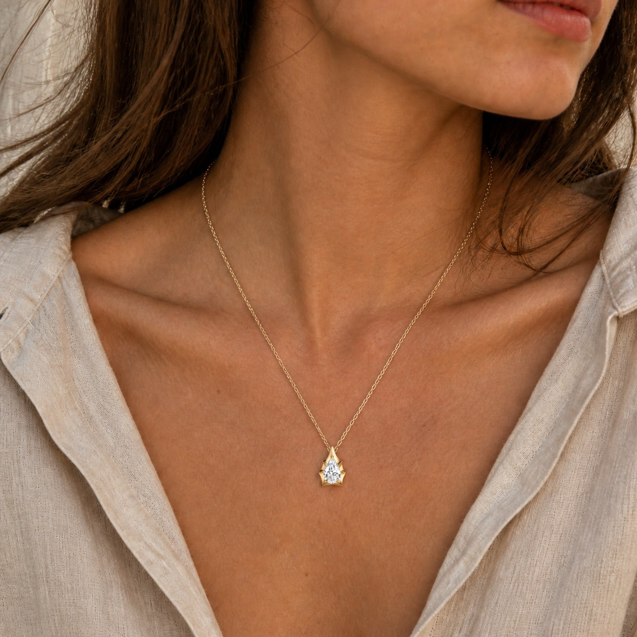 3 ct Pear-Cut Moissanite Bezel-Prong Pendant Necklace in 18k yellow gold vermeil, worn on a model.