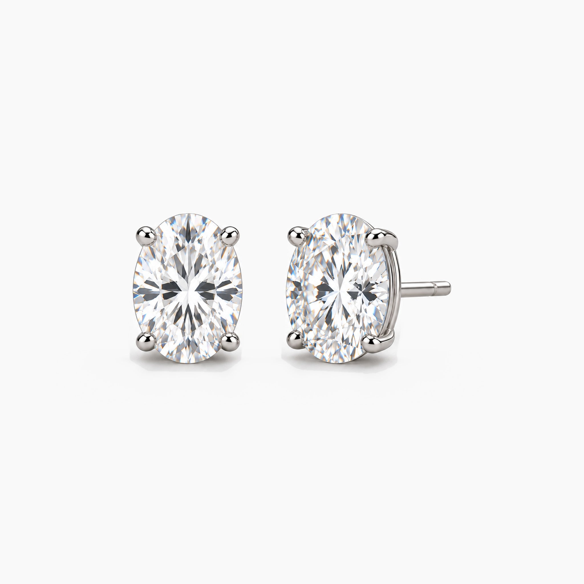 Oval-cut lab-grown diamond stud earrings in 14k white gold, front and three-quarter views.