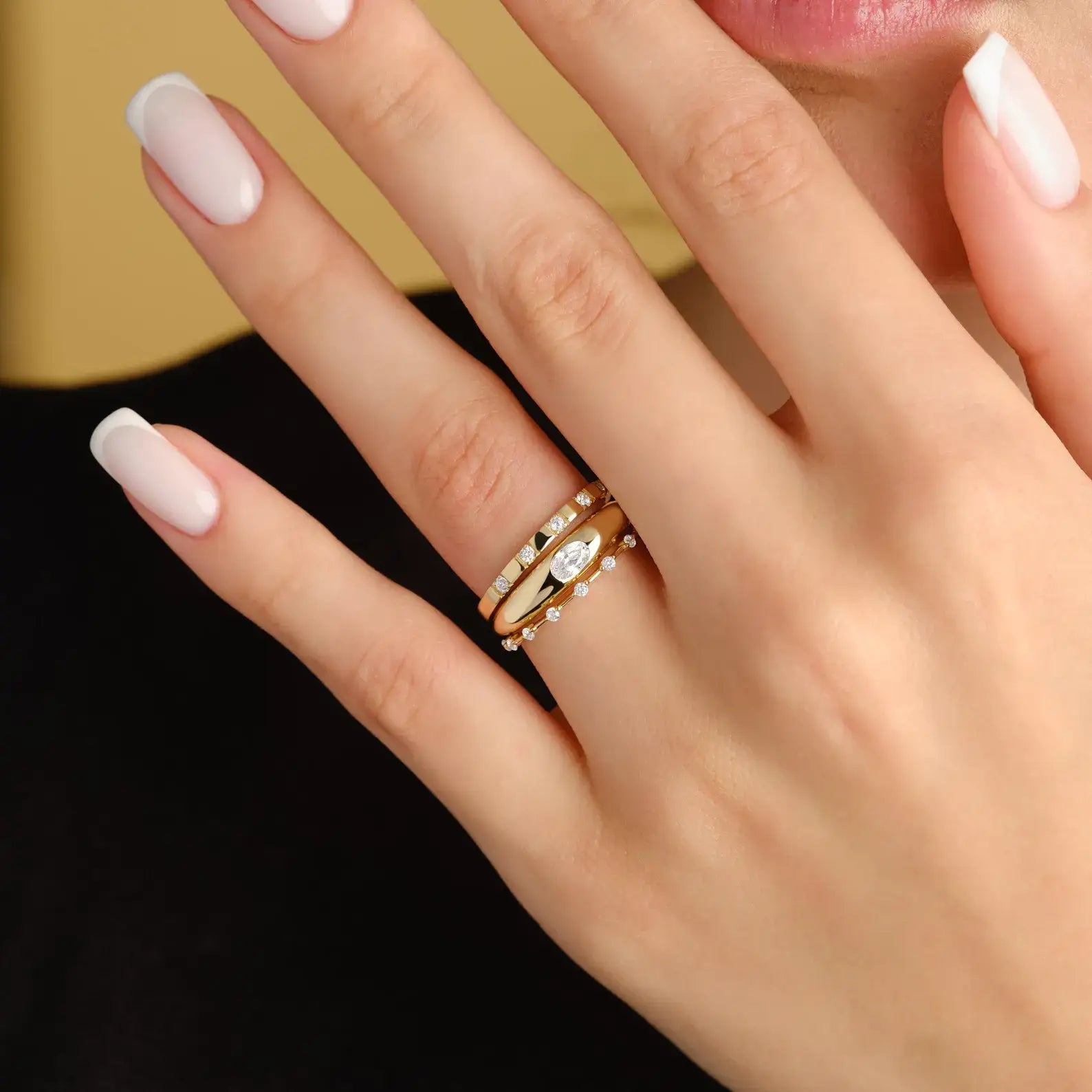 Oval-cut moissanite bezel dome ring worn on a finger.
