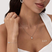 Oval-cut moissanite bezel pendant necklace worn at the neckline.