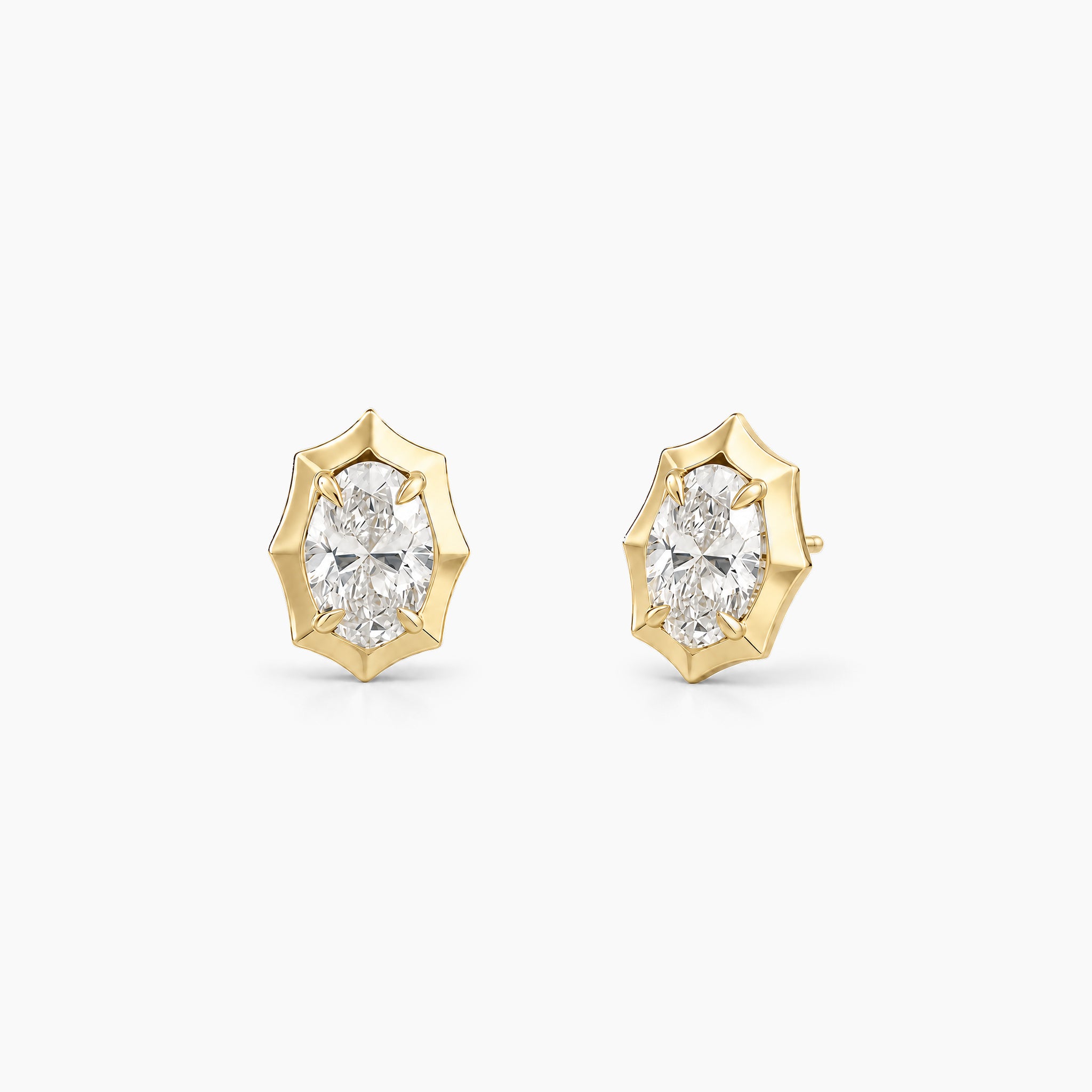 Oval-cut moissanite bezel-prong stud earrings in 18k yellow gold vermeil, front and angled views.