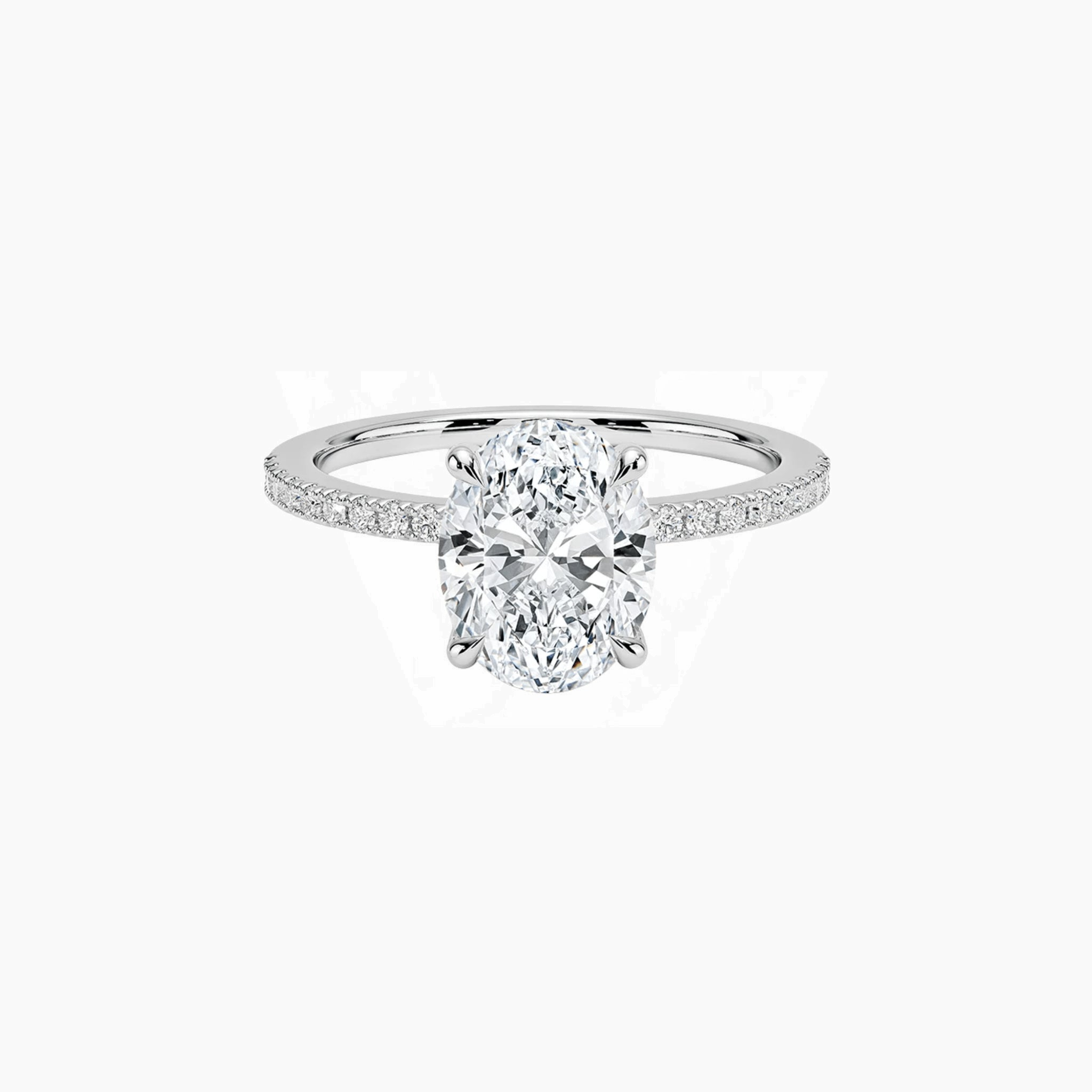 Oval-cut moissanite hidden halo ring with pavé band in white gold vermeil, front view.