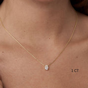 Oval-cut moissanite pendant necklace worn at the neckline.