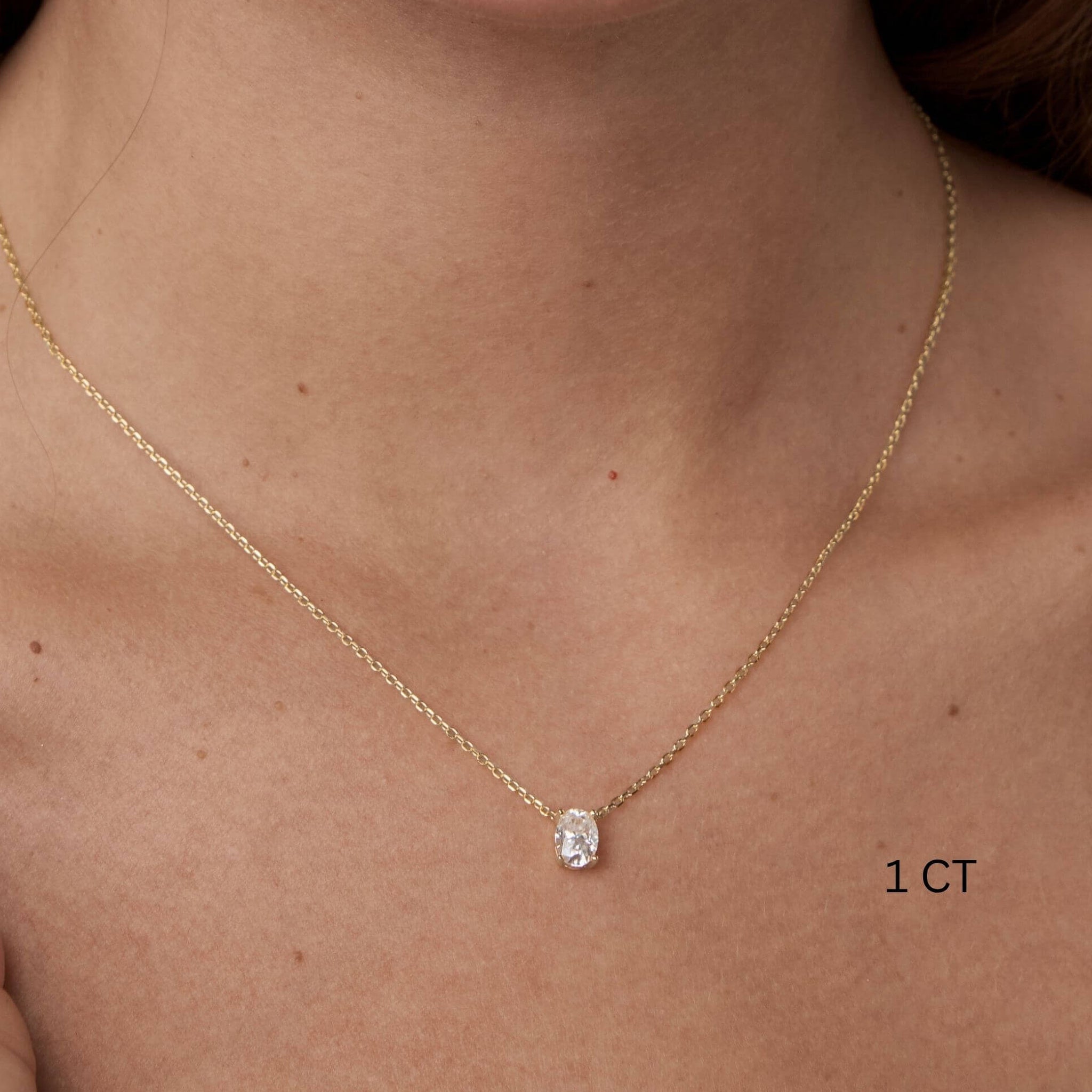 Oval-cut moissanite pendant necklace worn at the neckline.