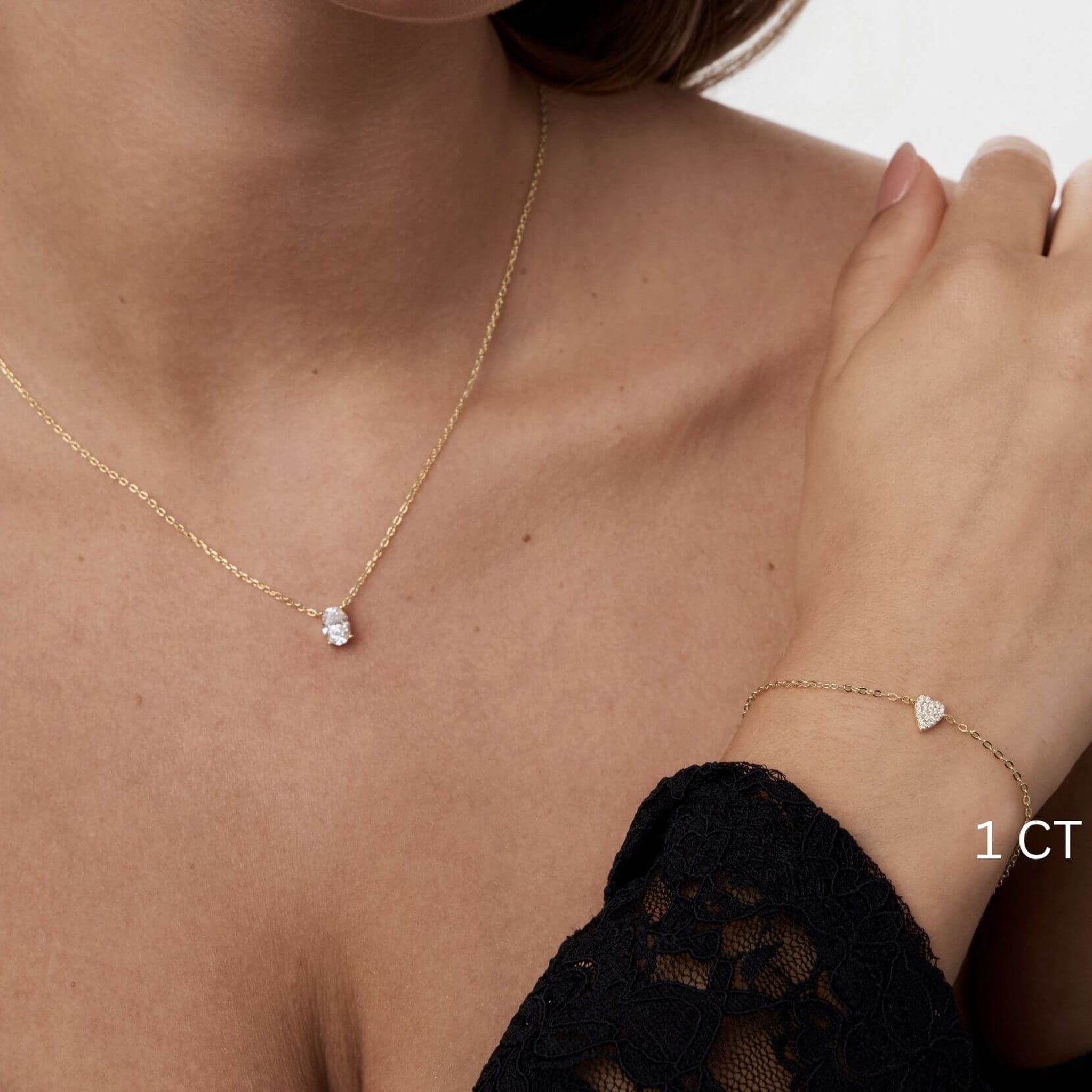 Oval-cut moissanite pendant necklace worn at the neckline.