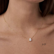 Oval-cut moissanite pendant necklace worn at the neckline.
