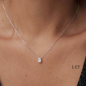 Oval-cut moissanite pendant necklace worn at the neckline.