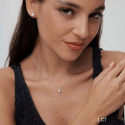 Oval-cut moissanite pendant necklace worn at the neckline.