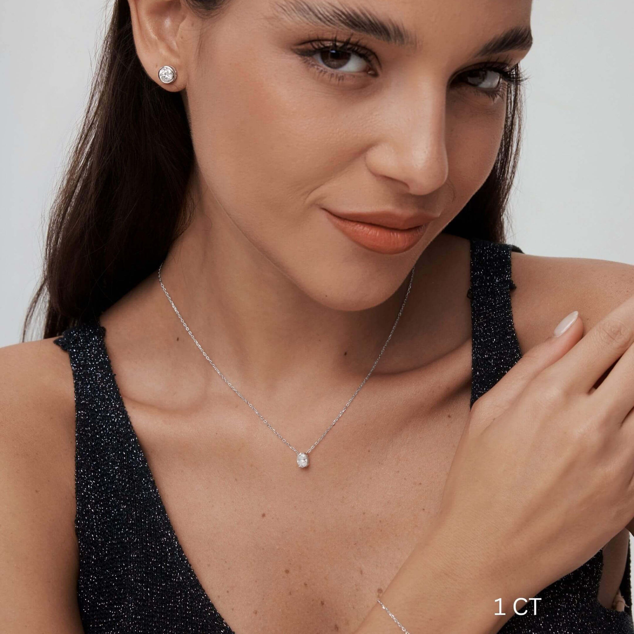 Oval-cut moissanite pendant necklace worn at the neckline.