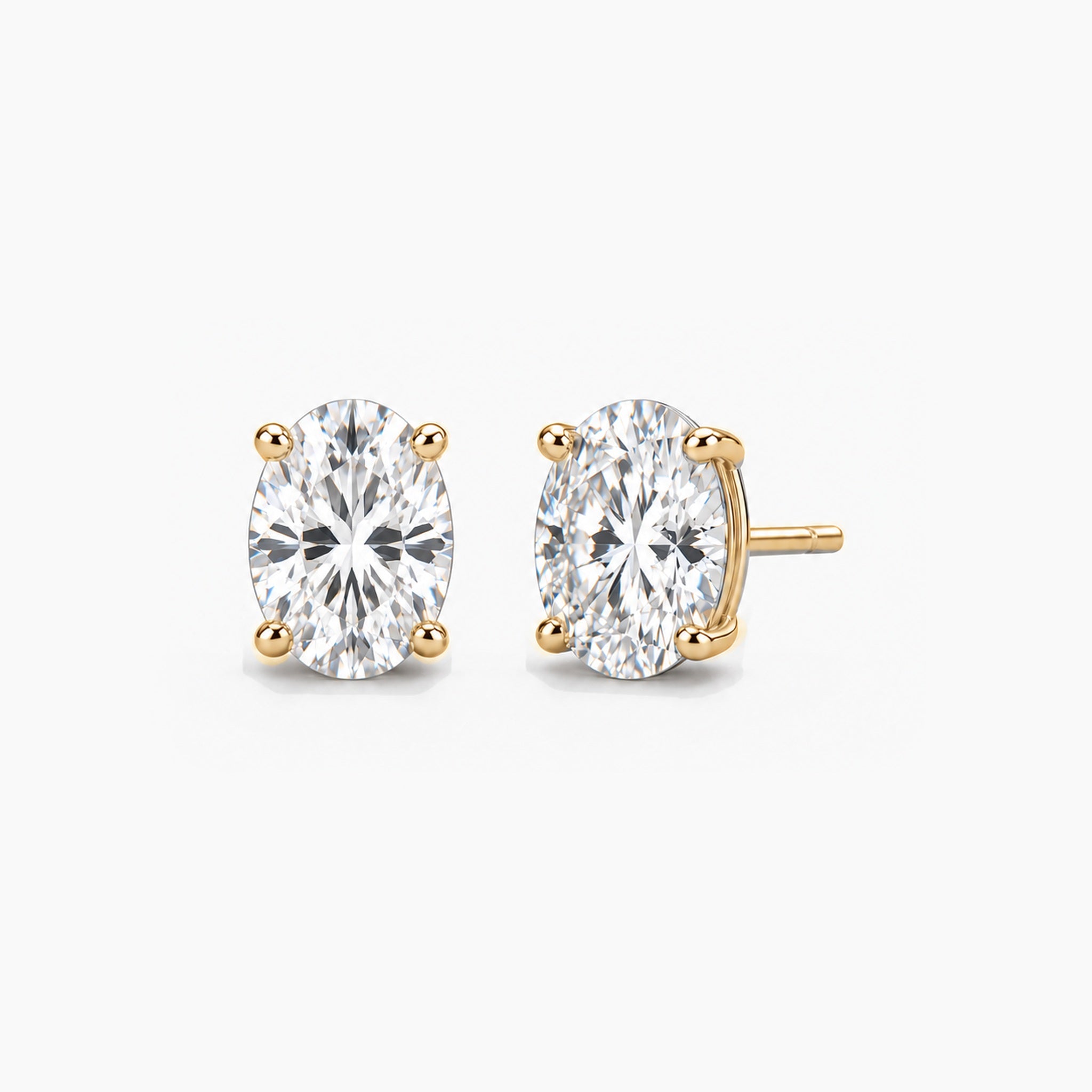 Oval-cut moissanite stud earrings in yellow gold vermeil, front and three-quarter views.