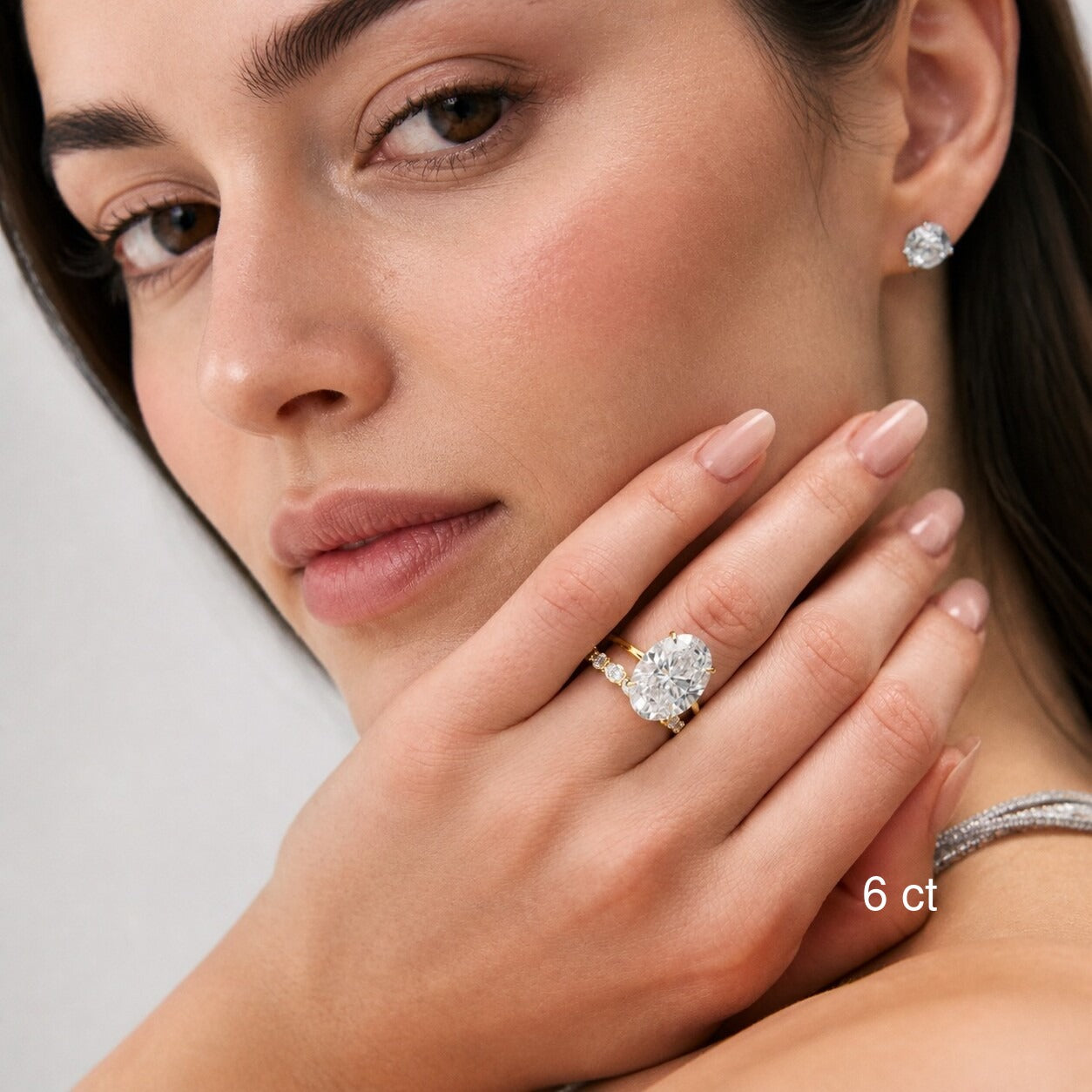 6 ct oval-cut moissanite ring in yellow gold worn with a stacking band