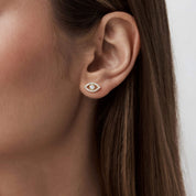 Pavé moissanite evil eye stud earrings worn on the ear.