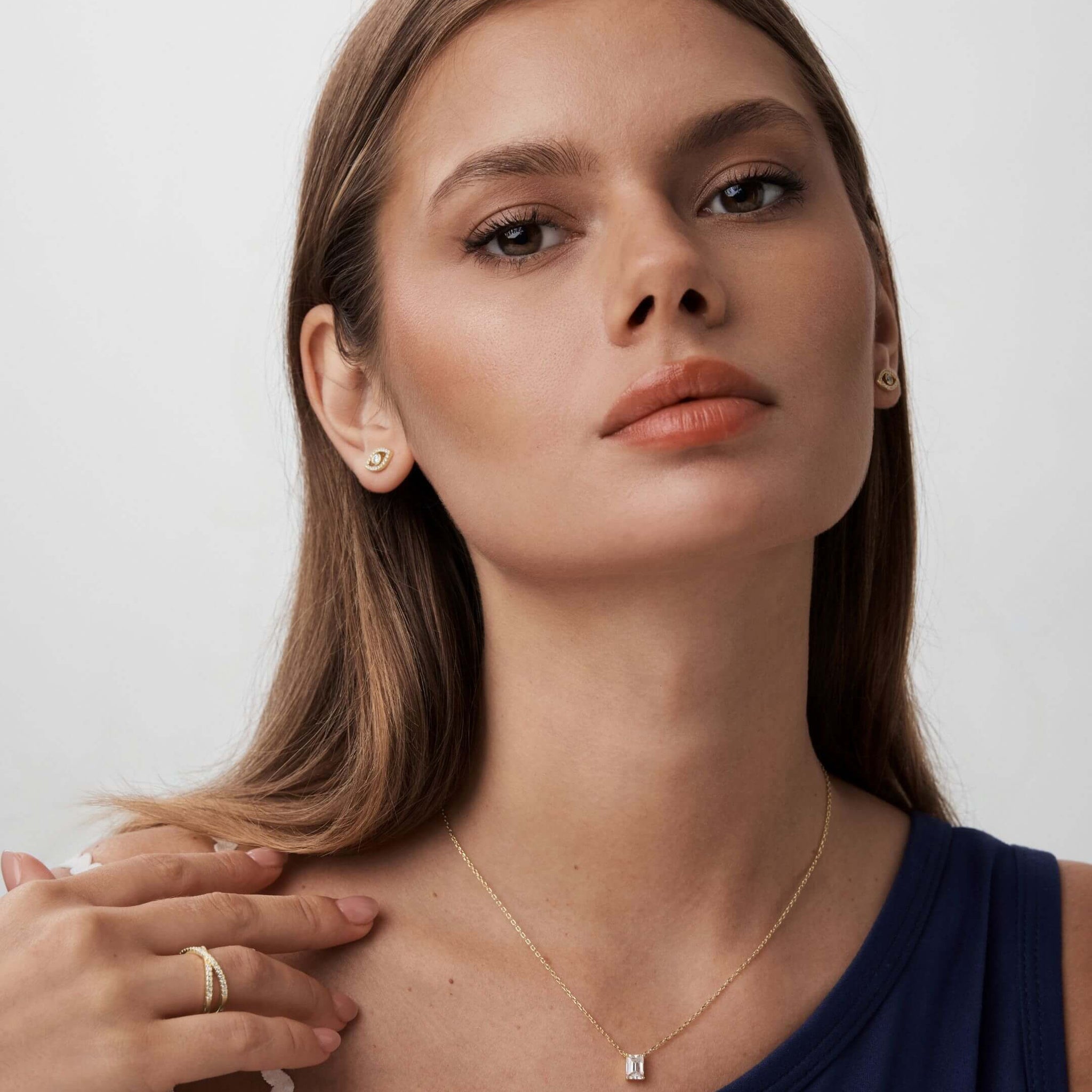 Pavé moissanite evil eye stud earrings worn on the ear.