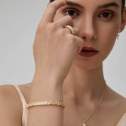 Pavé moissanite triangle-link tennis bracelet worn on the wrist.
