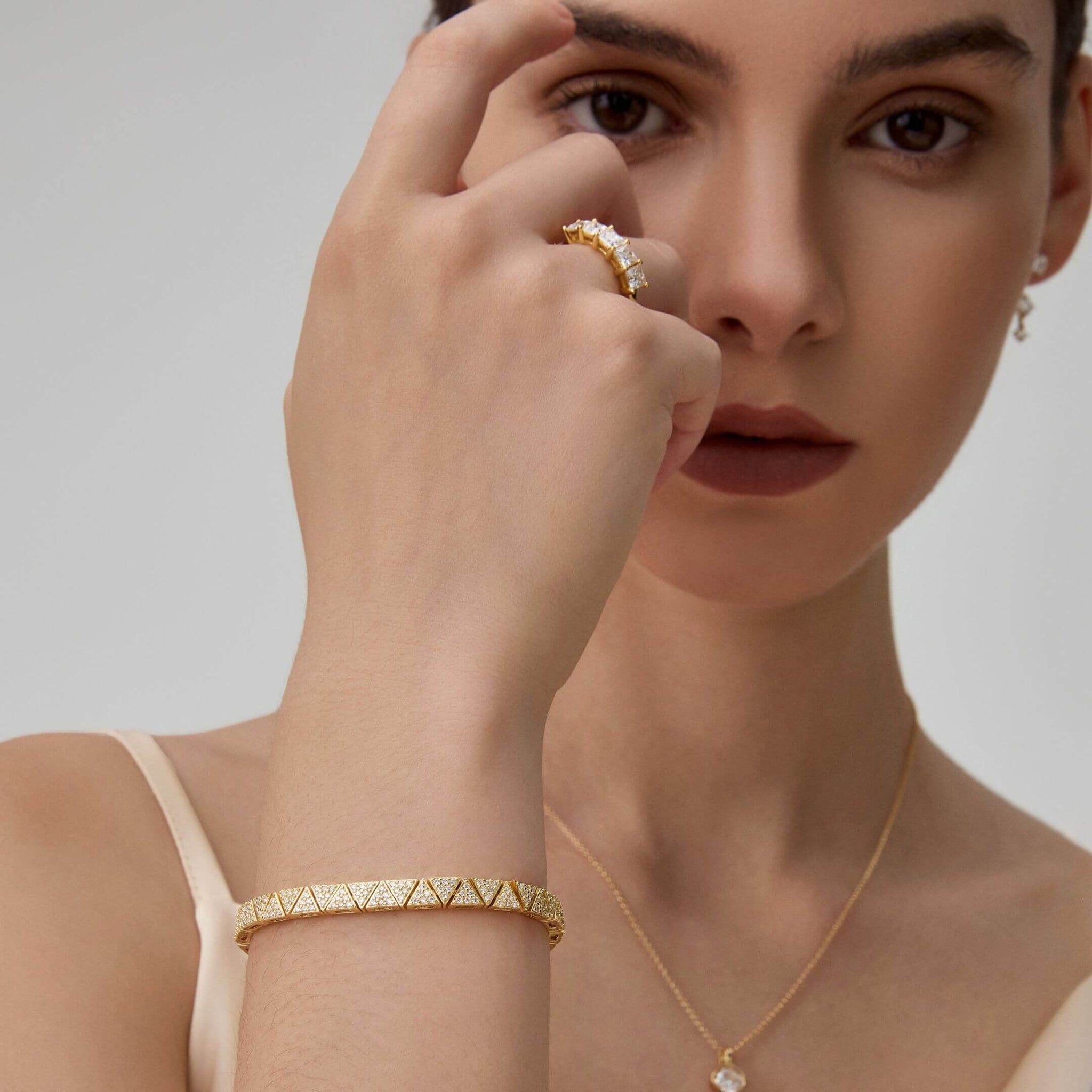 Pavé moissanite triangle-link tennis bracelet worn on the wrist.