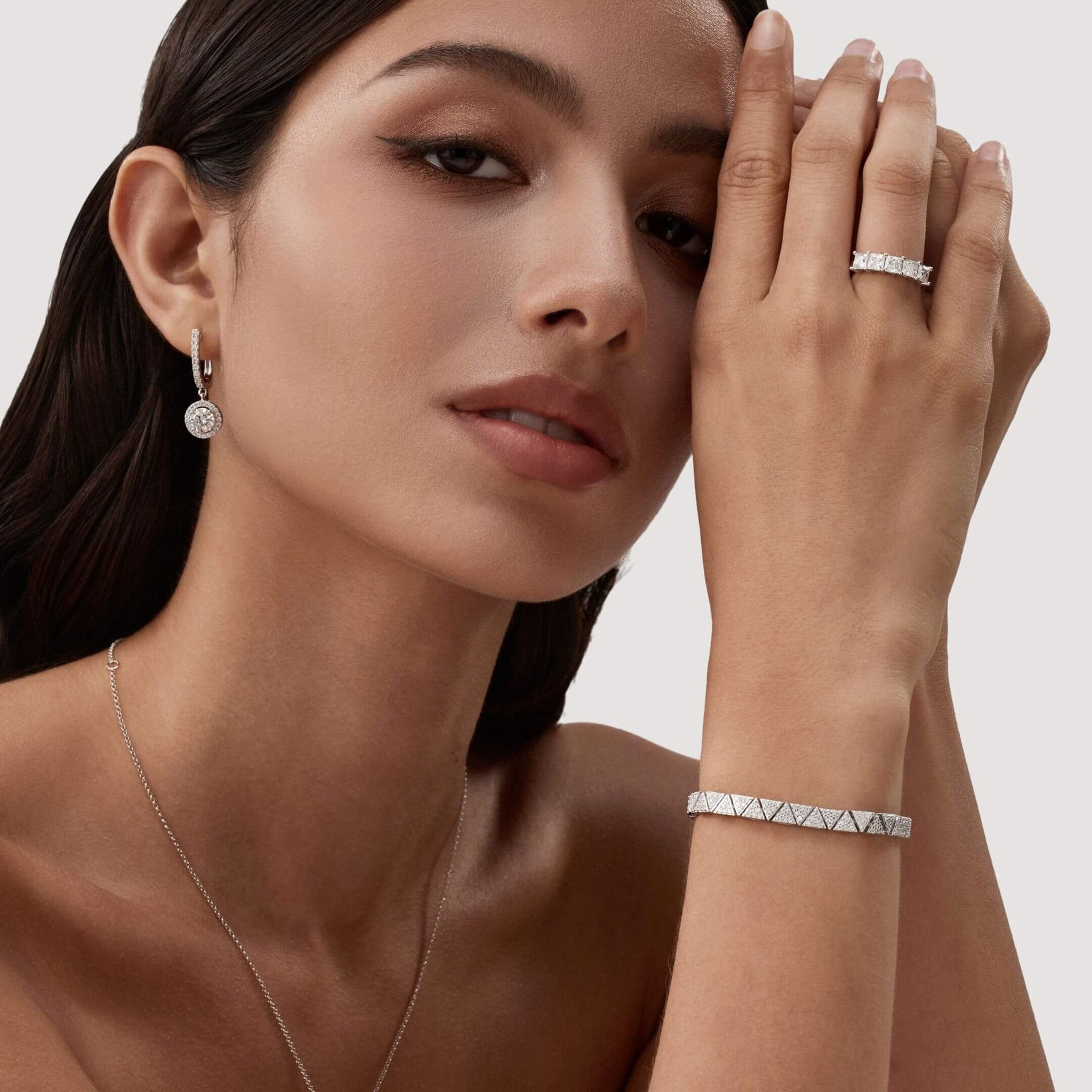 Pavé moissanite triangle-link tennis bracelet worn on the wrist.