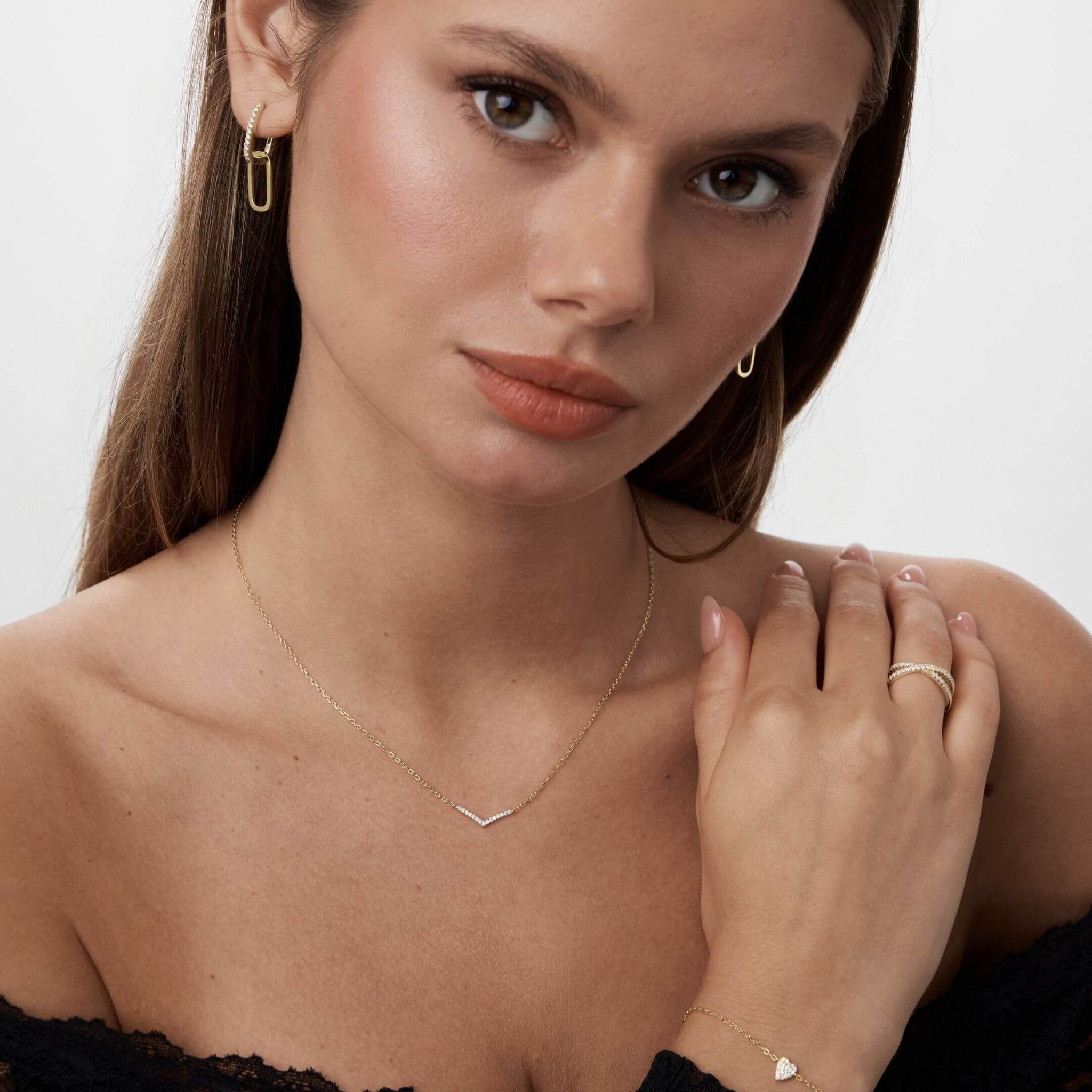 Pavé moissanite wishbone necklace worn at the neckline.