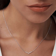 Pavé moissanite wishbone necklace worn at the neckline.