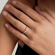 Pear-cut and marquise-cut moissanite cluster ring worn on a finger.