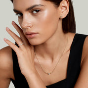 Pear-cut and marquise-cut moissanite cluster ring worn on a finger.